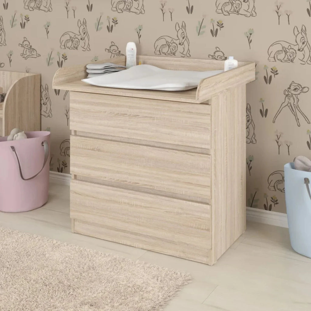 Oak baby changing top with padded changing mat on dresser, raised wooden sides