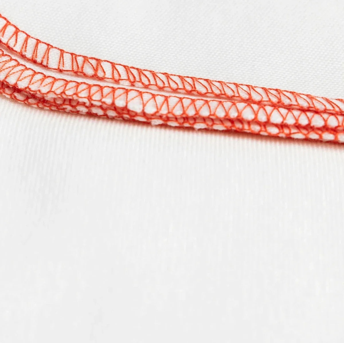 Ecru baby burp cloth edge with red stitched trim and detailed looping seam
