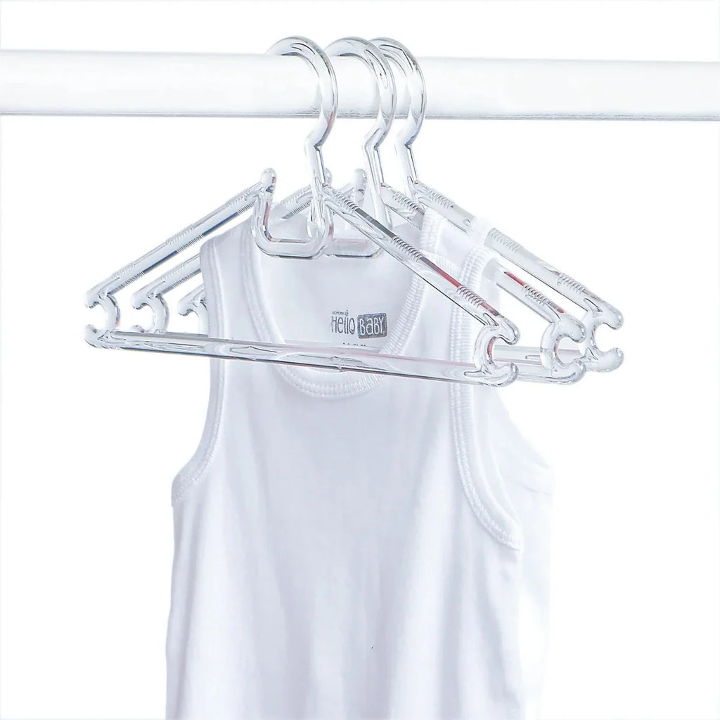 Clear baby clothes hangers on a white garment, curved shoulder hooks
