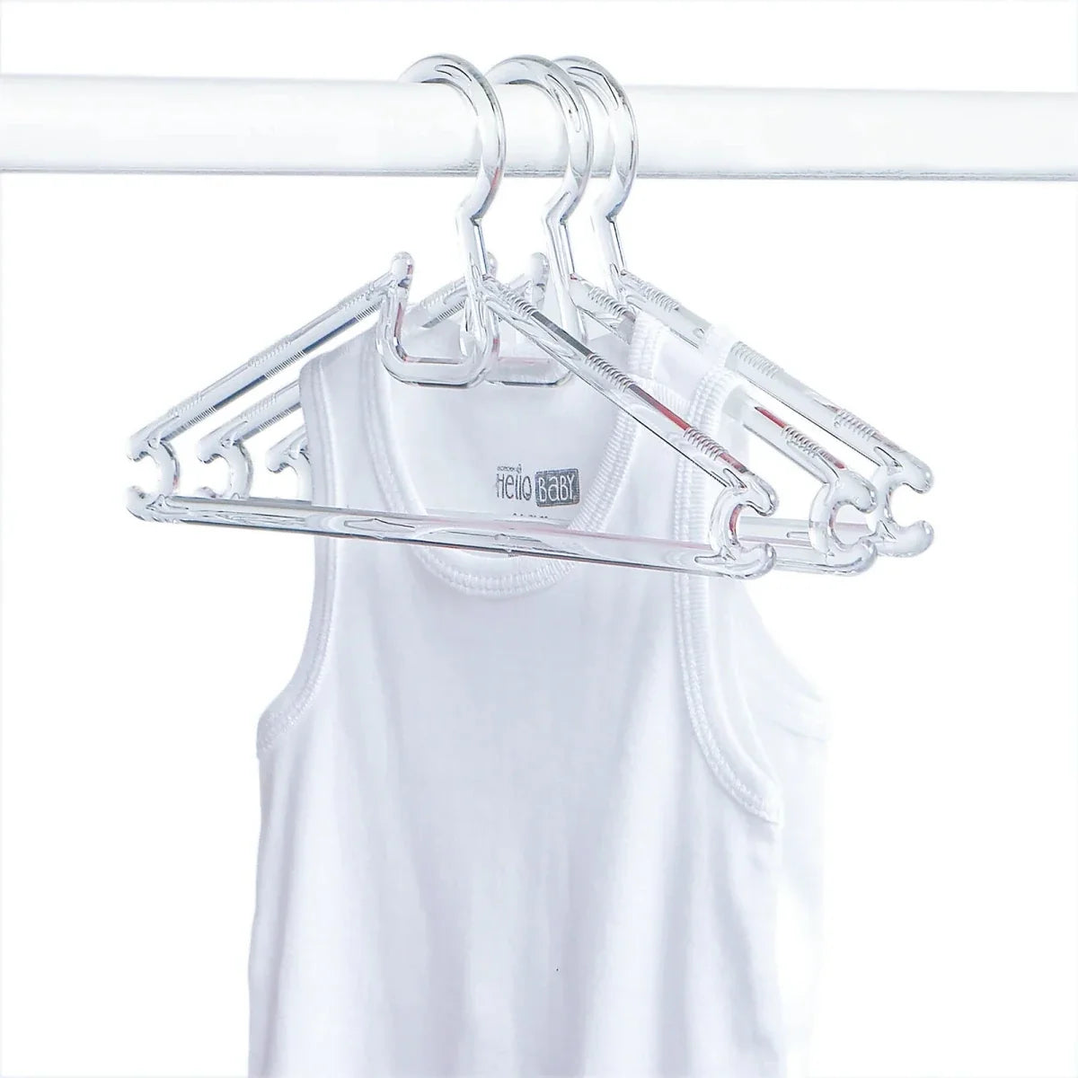 Clear baby clothes hangers on a white garment, curved shoulder hooks