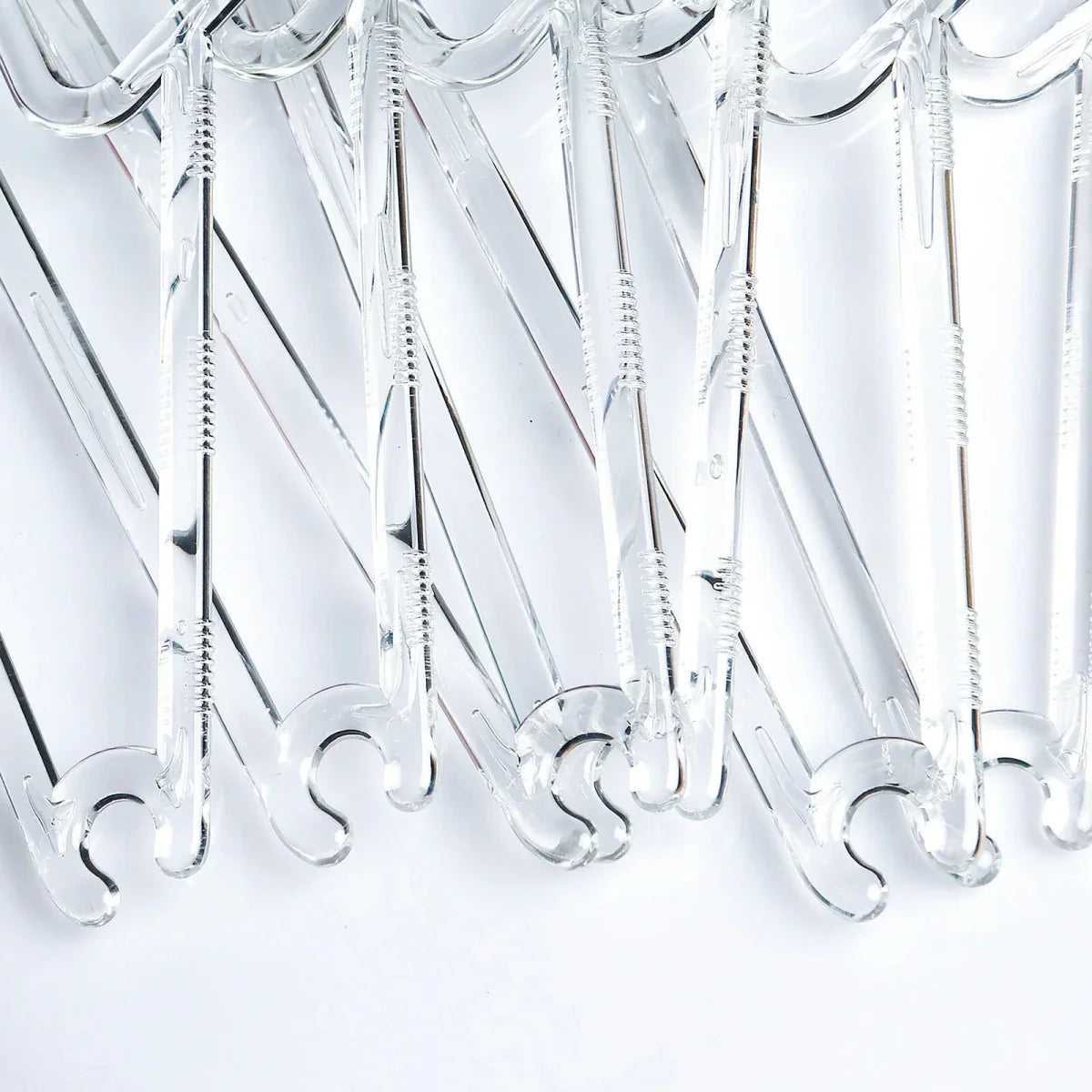 Crystal clear baby clothes hangers close-up showing multiple curved bottom hooks