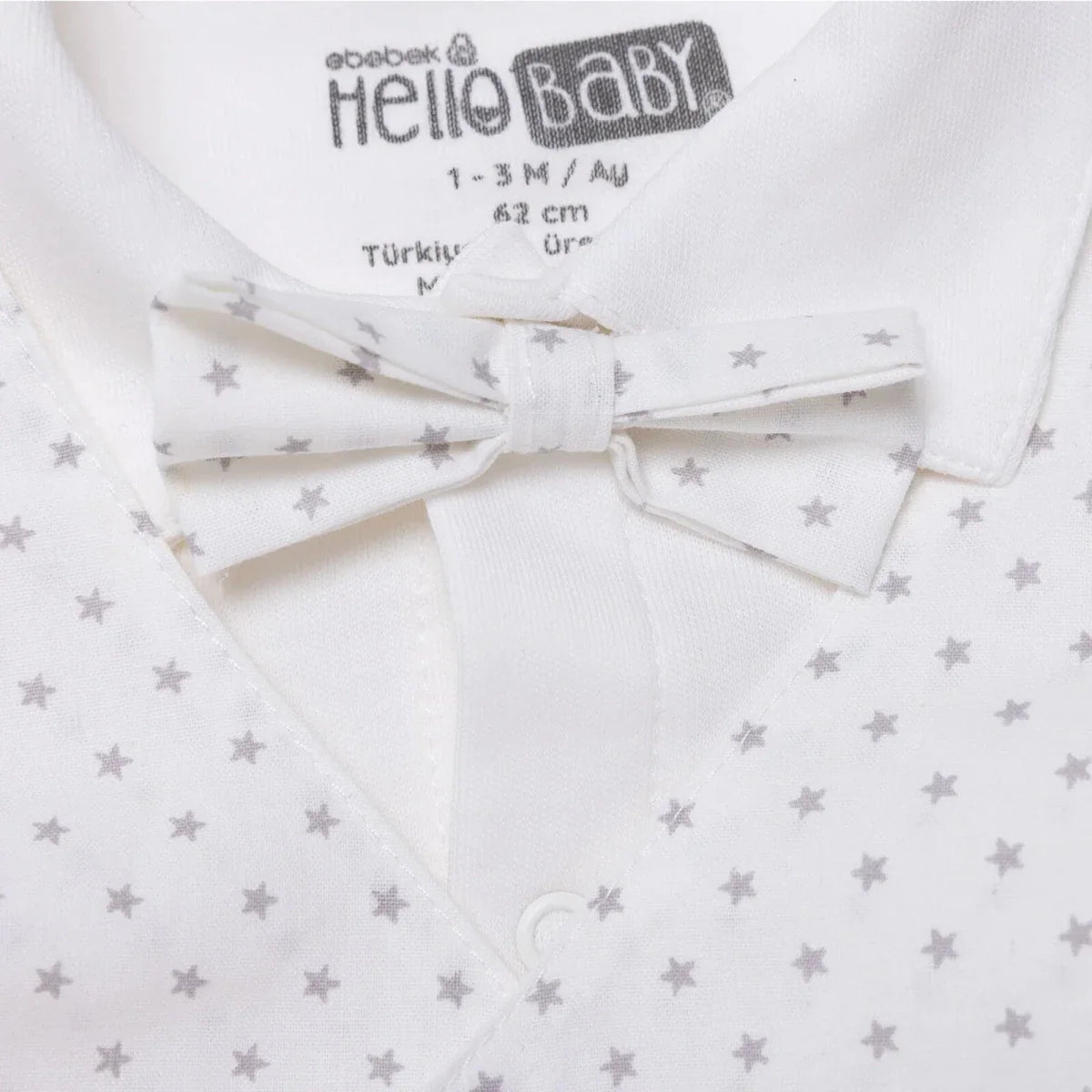 White collared baby outfit with star-printed bow tie at neckline