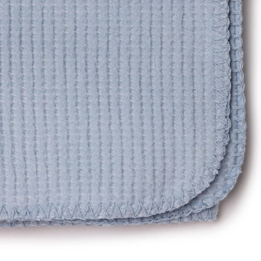 Blue waffle-knit baby blanket close-up of stitched border and folded corner