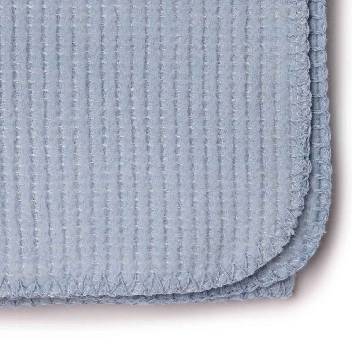 Blue waffle-knit baby blanket close-up of stitched border and folded corner