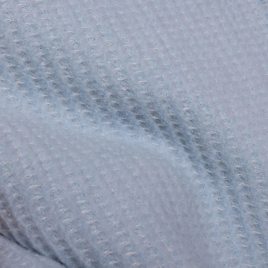 Blue waffle-knit fabric surface of the baby blanket, close-up texture