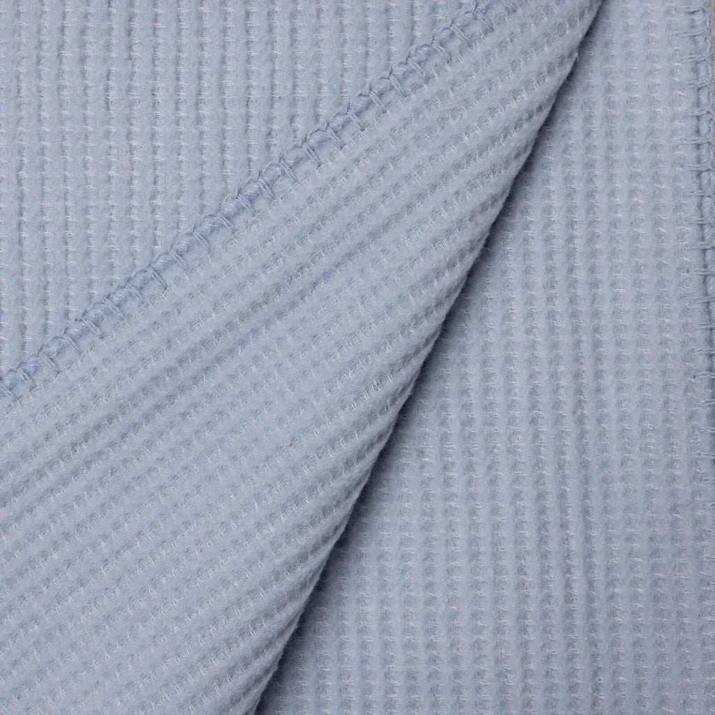 Blue waffle-knit baby blanket close-up of layered folds and seam detail