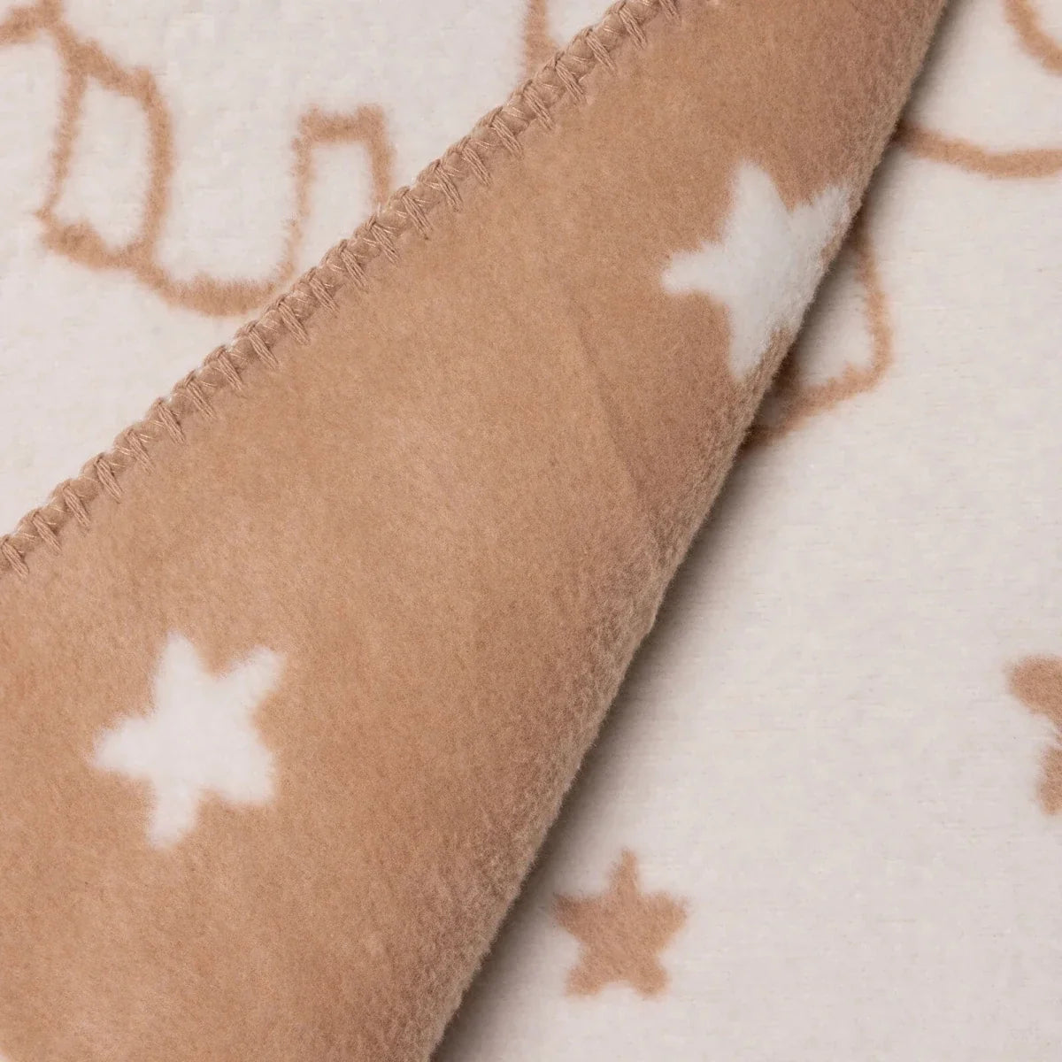 Jacquard knit baby blanket detail showing light brown reverse with star pattern