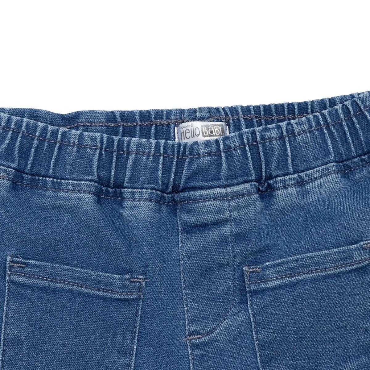 Indigo denim trousers close-up: elastic waistband and two front patch pockets