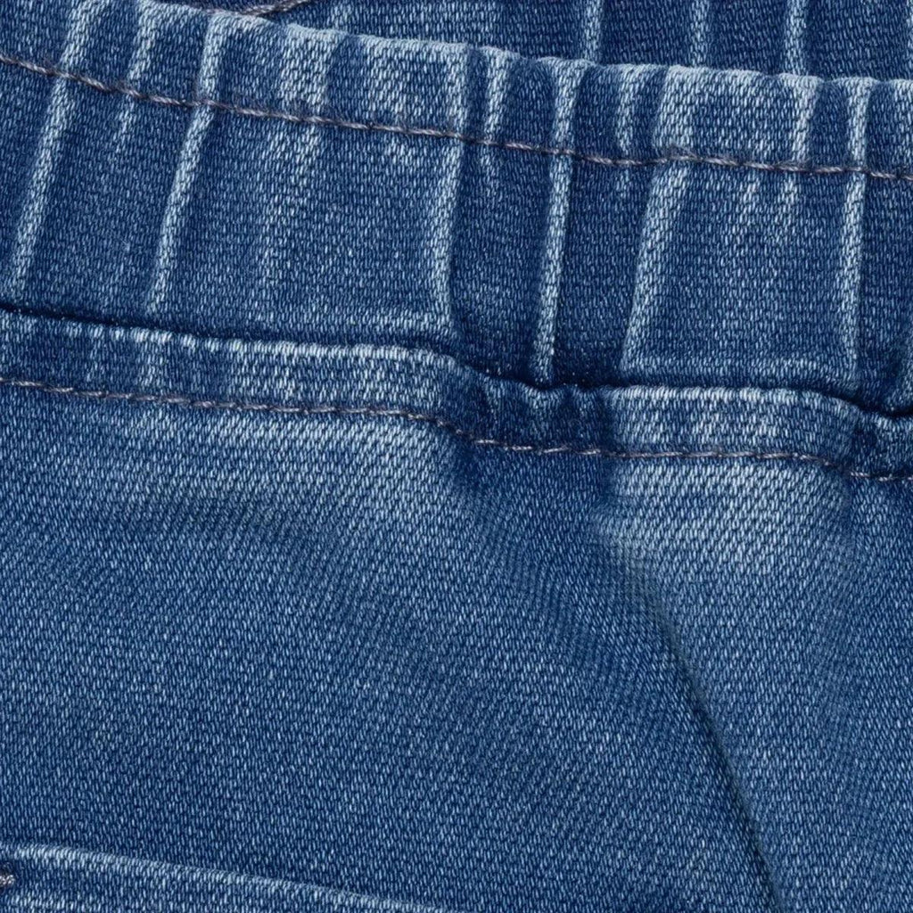 Indigo denim trousers waistband close-up with elastic seam and stitching