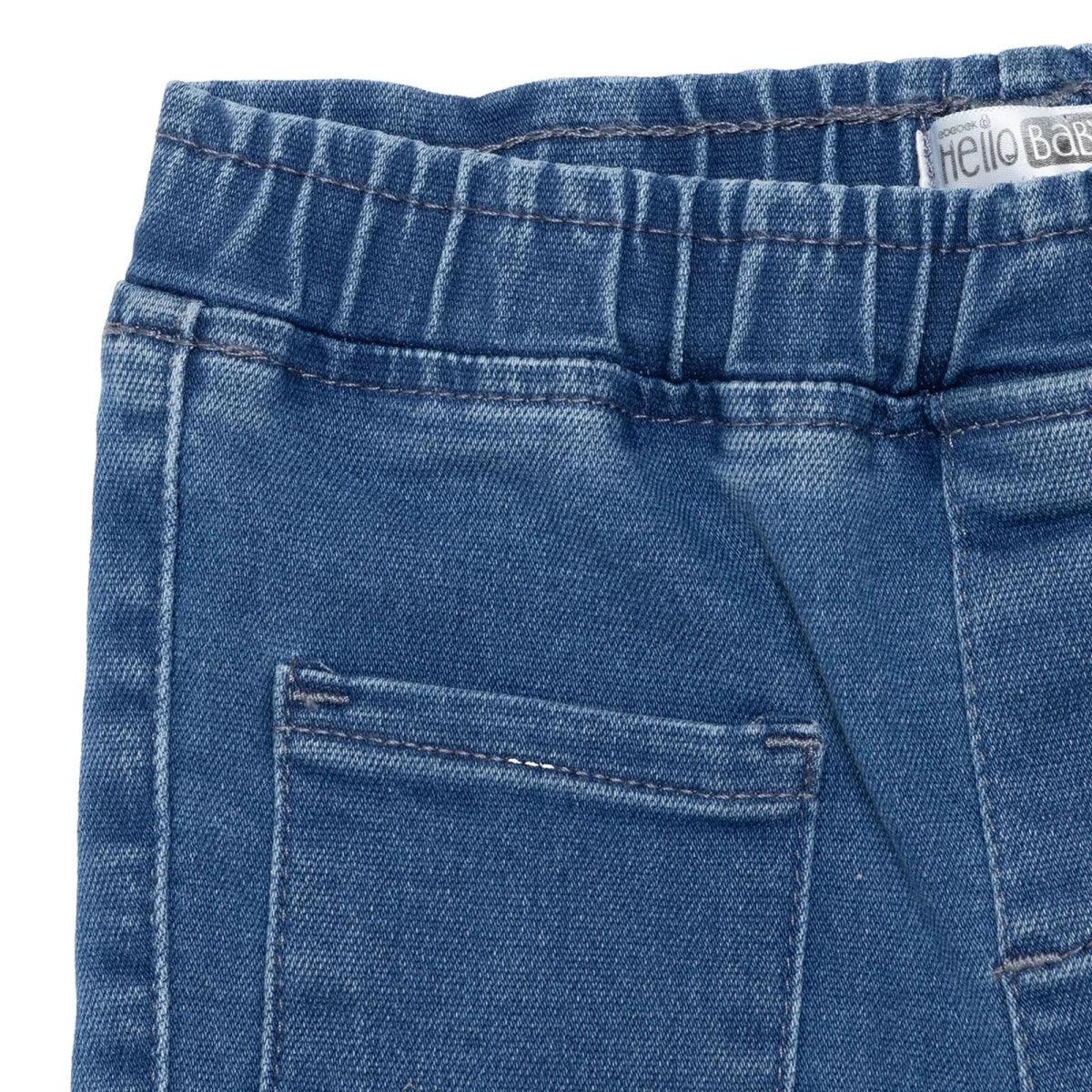Indigo denim trousers close-up of elastic waist and side patch pocket