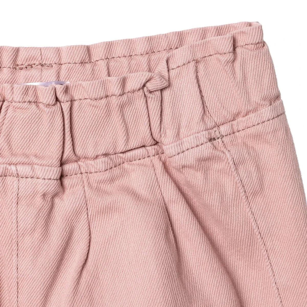 Pink baby trousers close-up of waist button and stitched panel seams