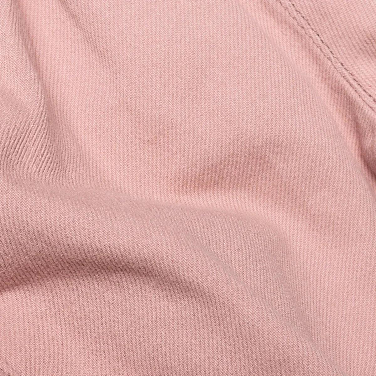 Pink baby trousers fabric close-up with fine woven texture