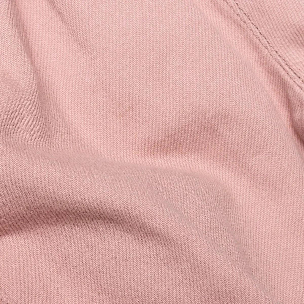 Pink gabardine baby trousers fabric close-up with smooth texture