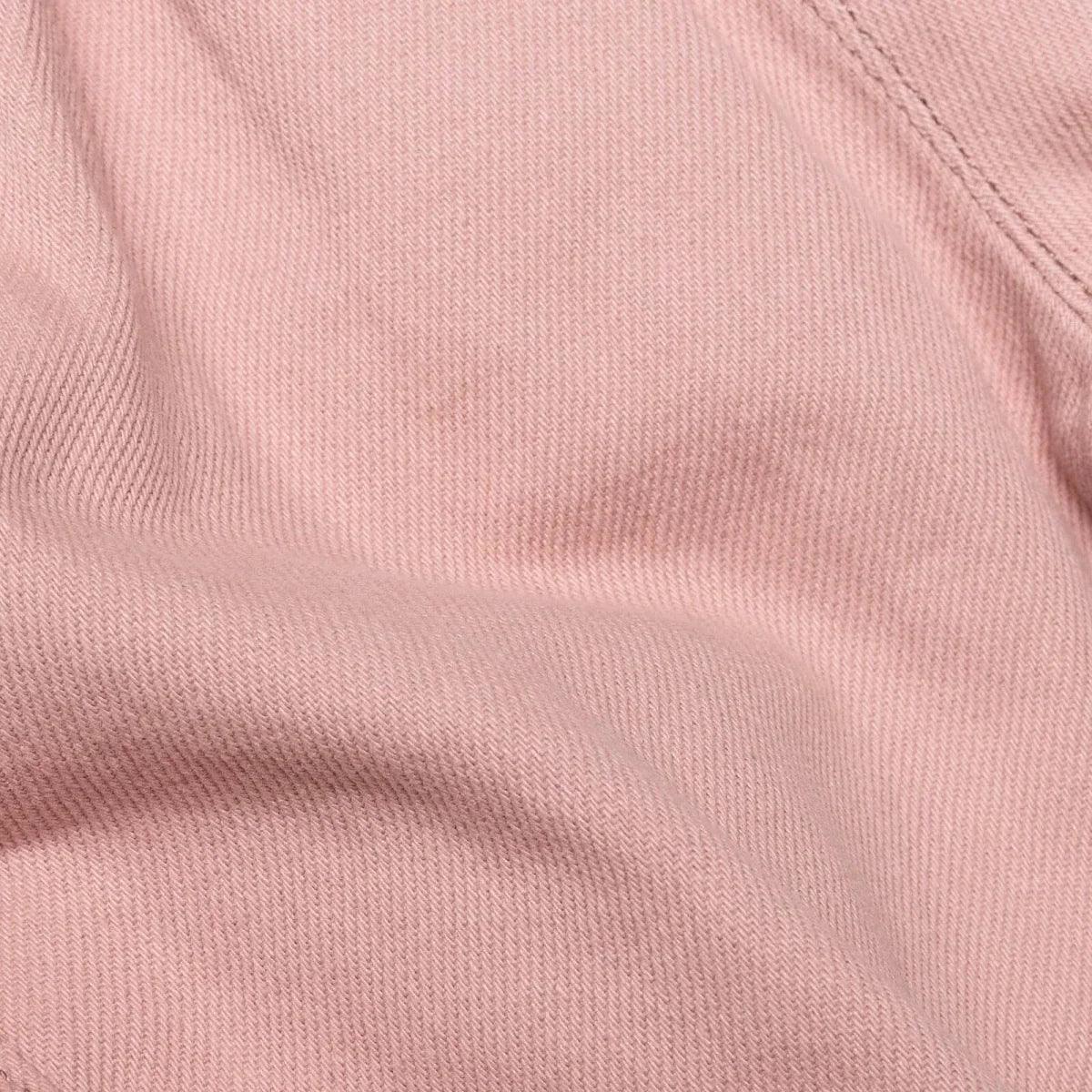 Pink gabardine baby trousers fabric close-up with smooth texture
