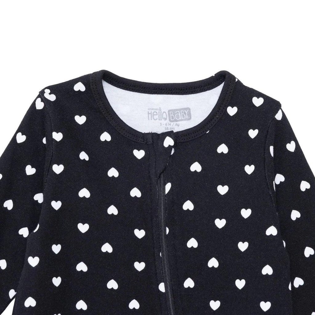 Black baby sleepsuit close-up: long sleeves, front zipper, white heart print