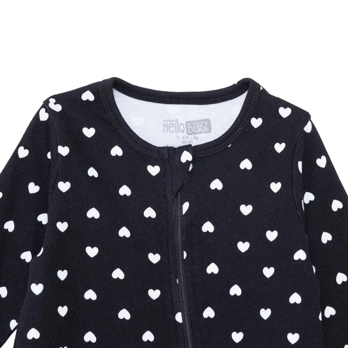 Black baby sleepsuit close-up: long sleeves, front zipper, white heart print
