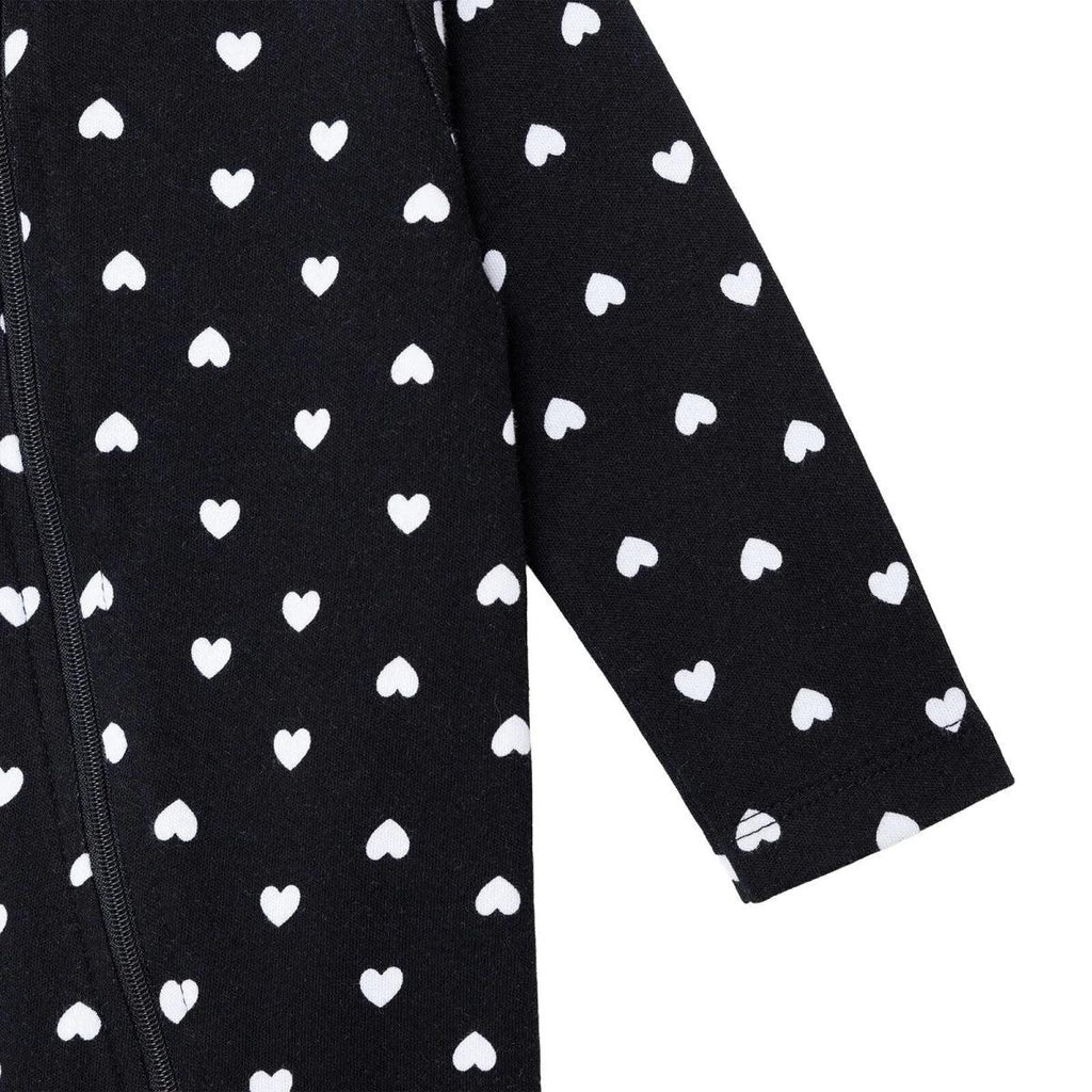 Black sleeve close-up with white heart pattern and zipper seam
