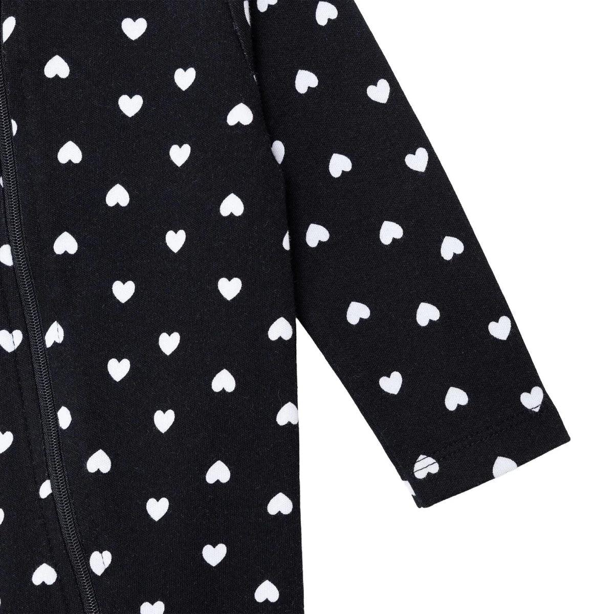 Black sleeve close-up with white heart pattern and zipper seam