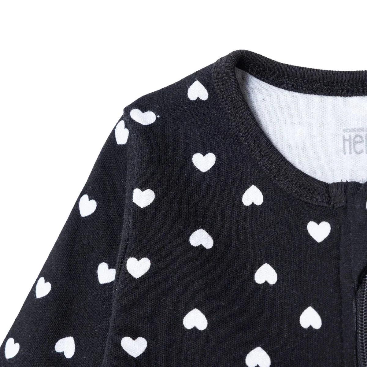 Black long-sleeve baby sleepsuit shoulder close-up, white heart print, neckline