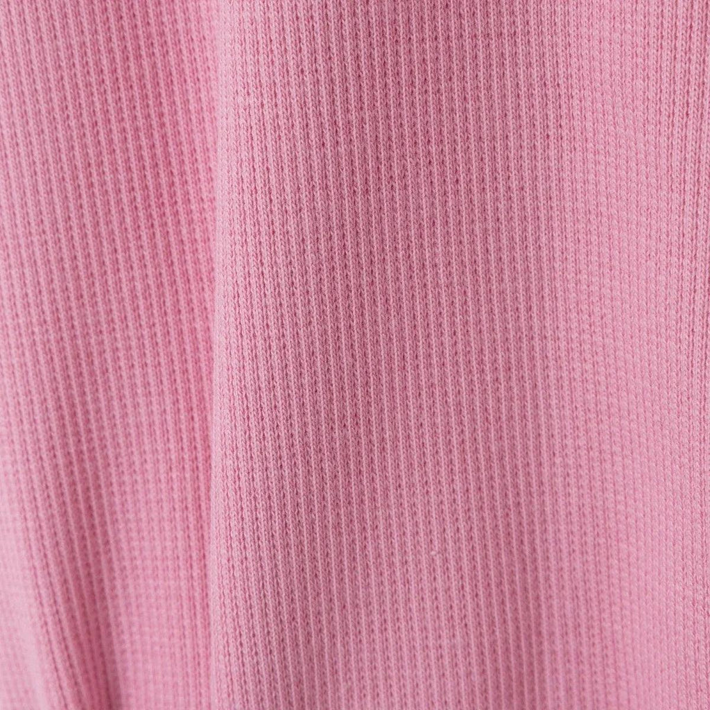 Pink ribbed fabric texture close-up on baby sleepsuit