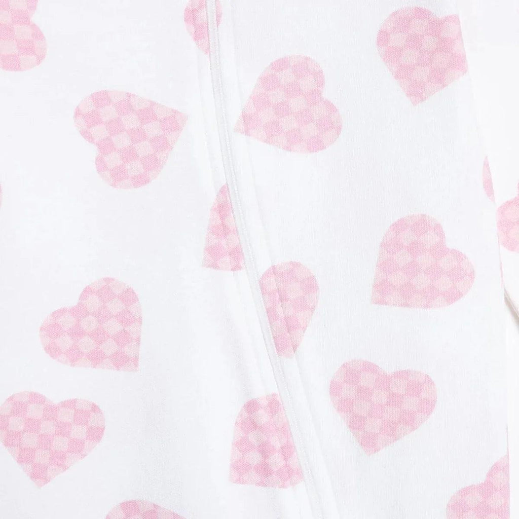 Front placket seam detail on baby sleepsuit, white with pink heart print