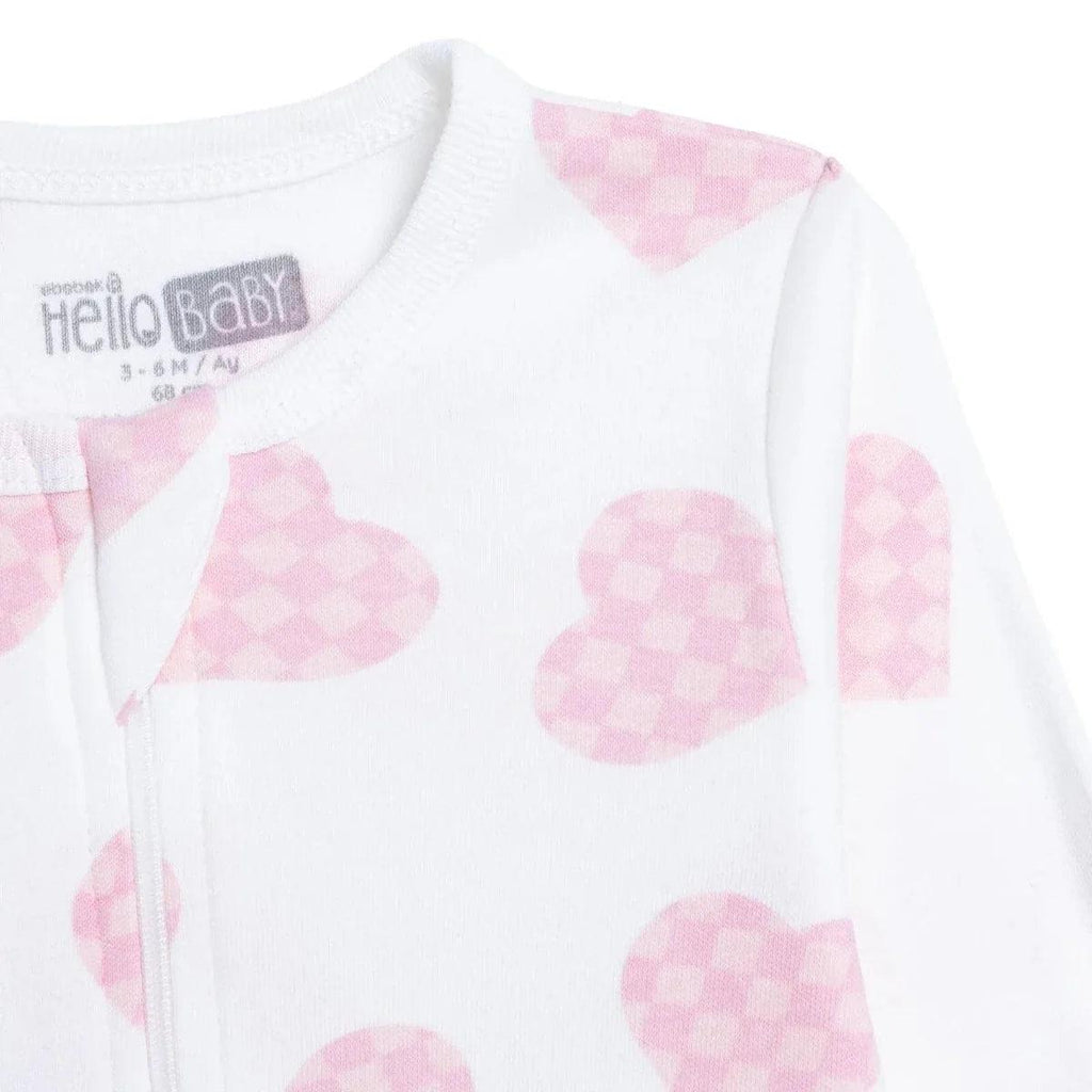 Sleepsuit collar and tag area, white fabric with pink heart print