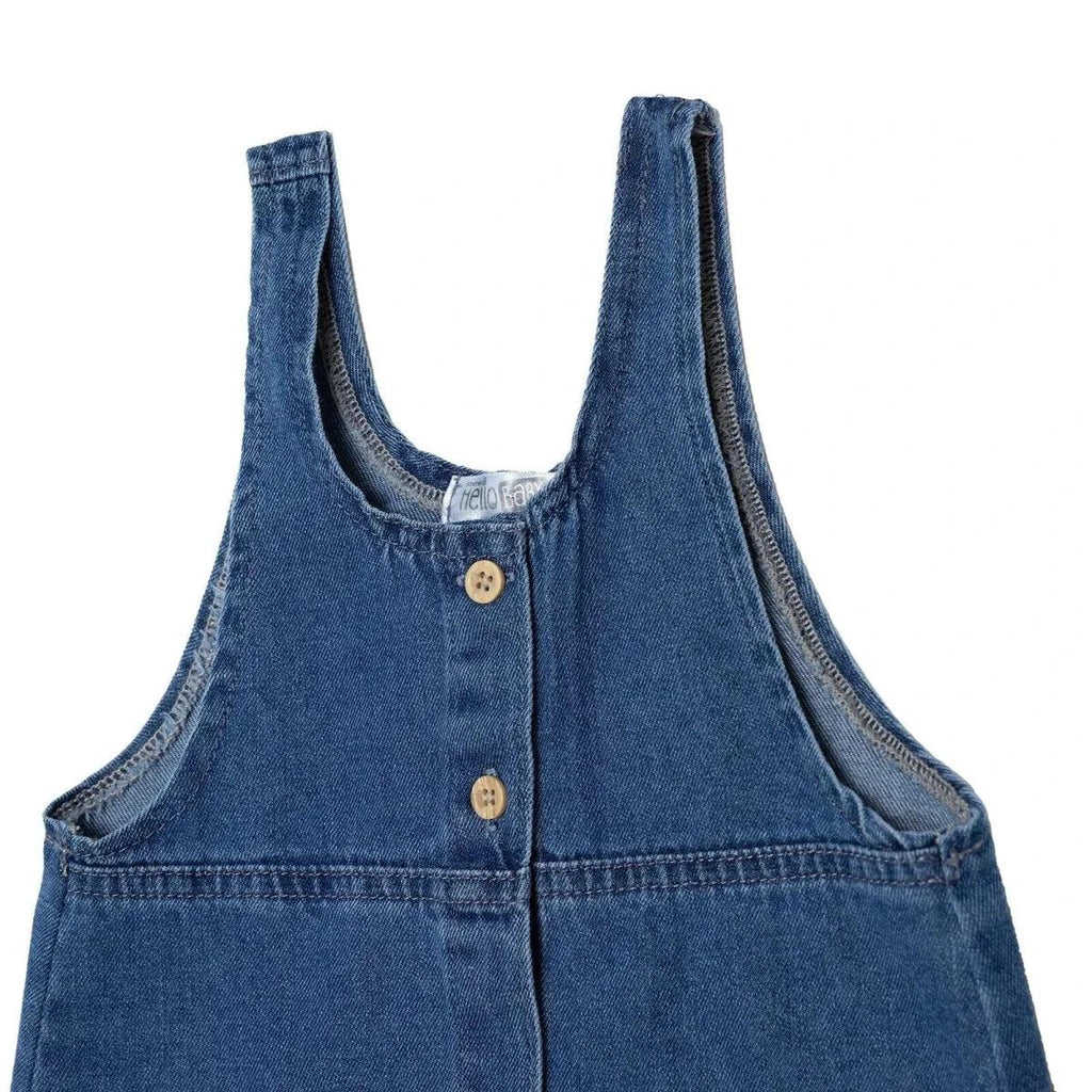 Indigo denim pinafore dress close-up of neckline and bib with wooden-look buttons