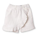Ecru baby skort with elastic waistband and ruffled hem over built-in shorts