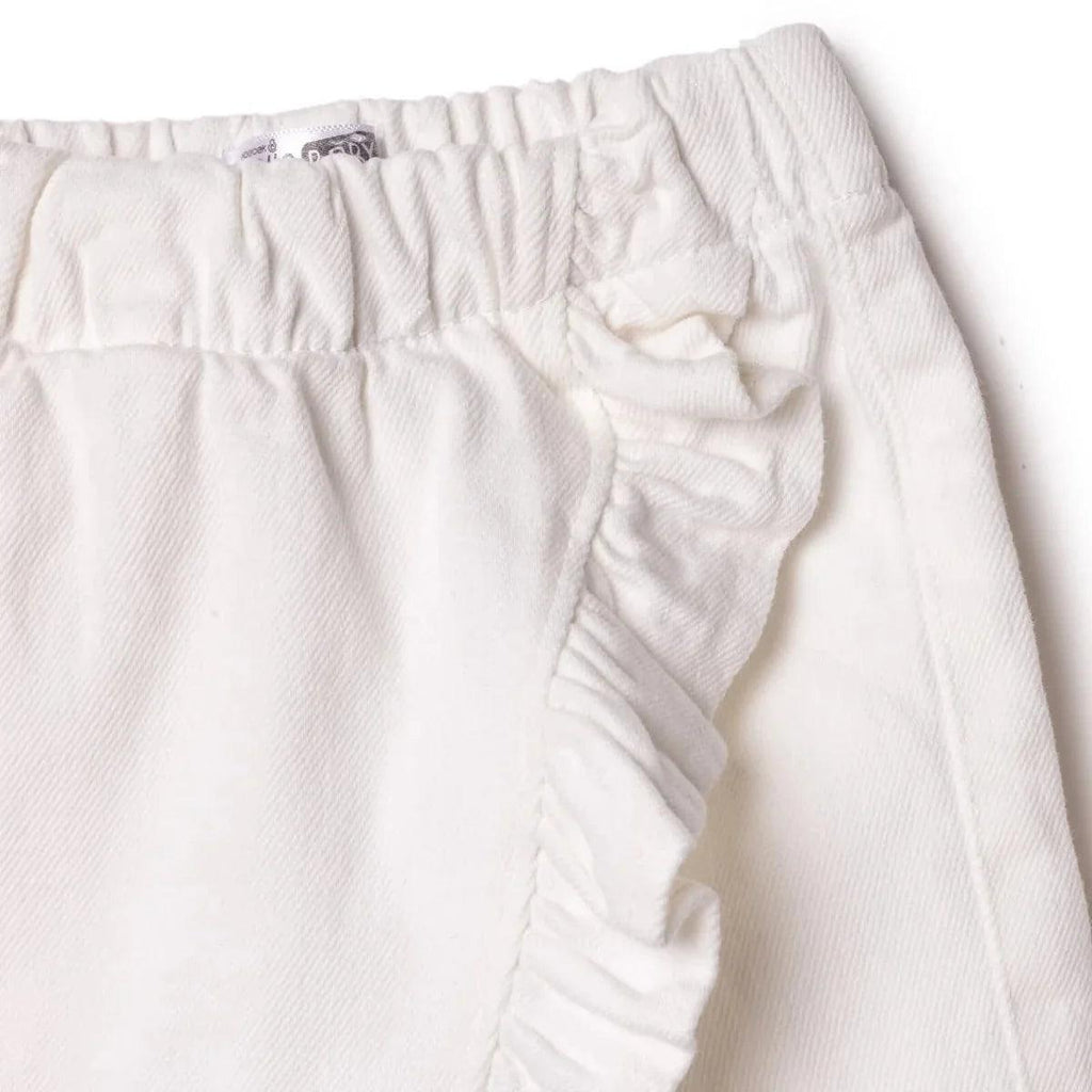 Ecru baby skort close-up of side ruffle trim and gathered skirt overlay