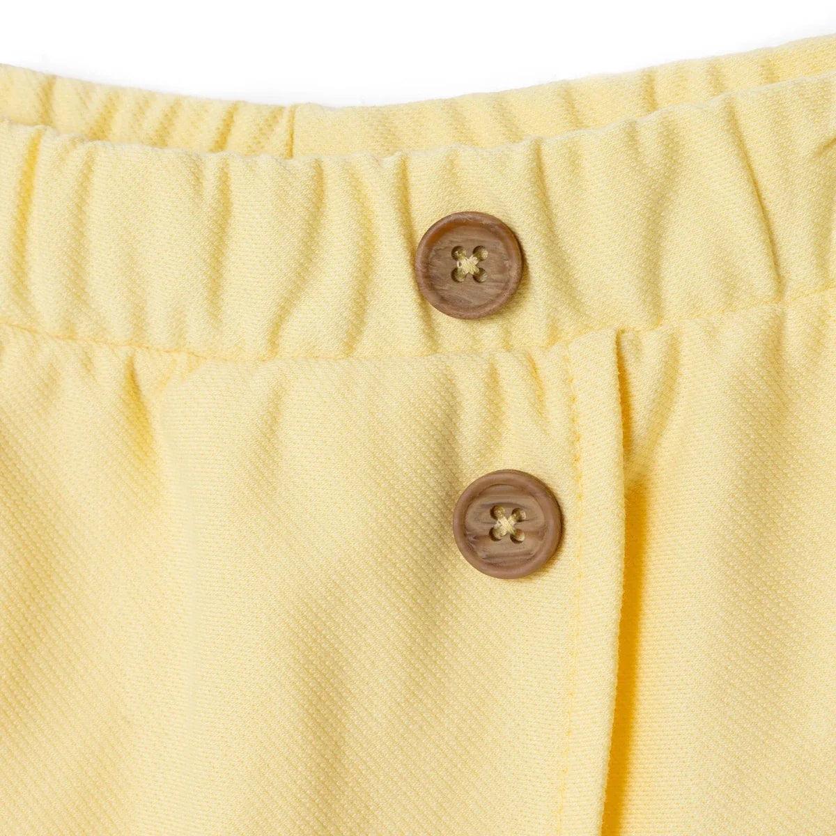 Yellow baby skort button placket close-up with elastic waist