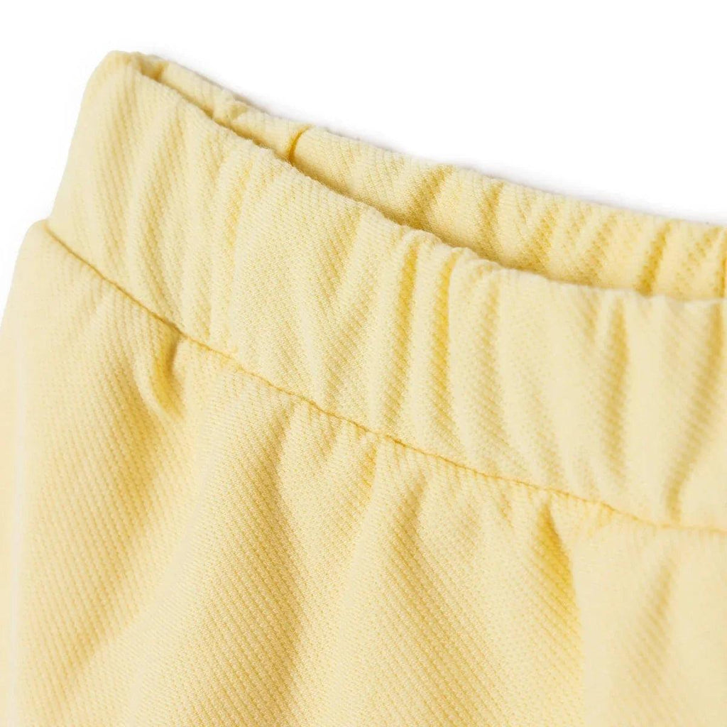 Yellow baby skort with gathered waistband and curved hem