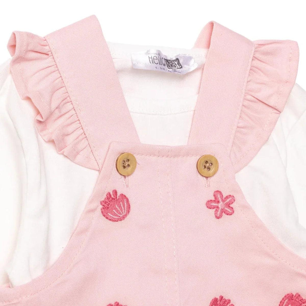 Pink dungarees with ruffled straps, two wooden-style buttons, tulip and flower embroidery