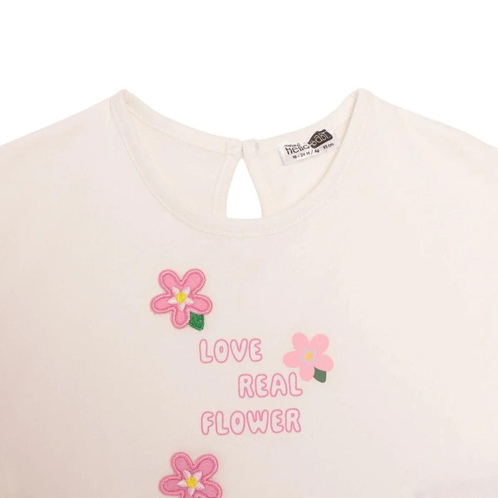 Ecru baby t-shirt with keyhole neckline and Love Real Flower flower graphic.
