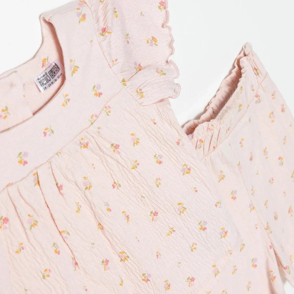 Pink floral baby top close-up, ruffled flutter sleeves and gathered bodice