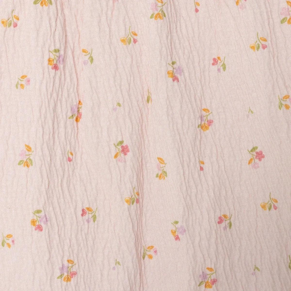 Pink floral baby shorts fabric close-up, crinkle texture with tiny prints