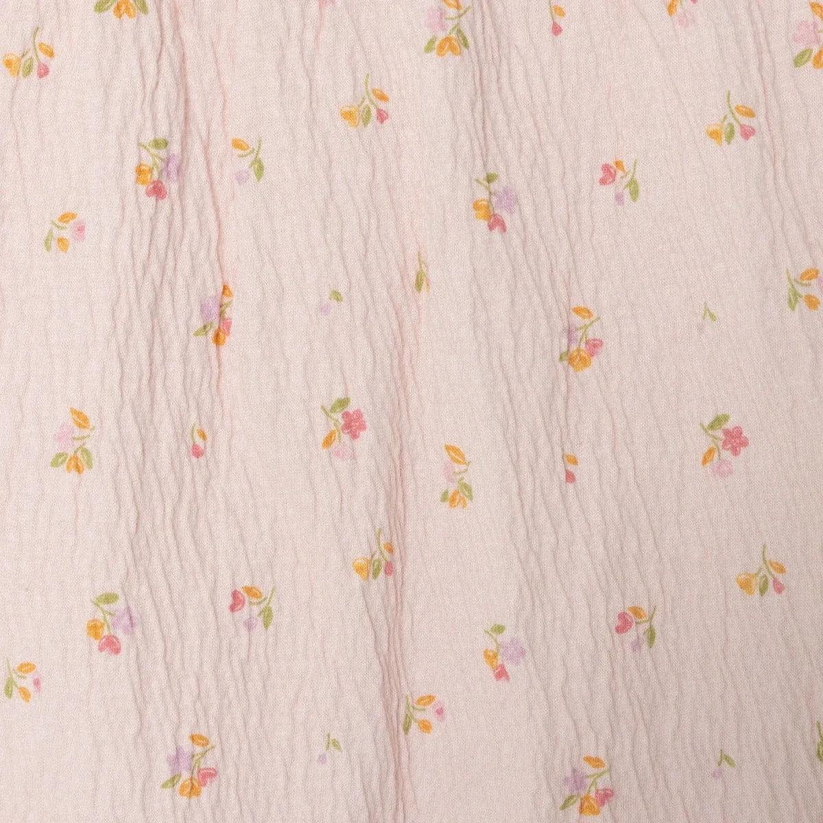 Pink floral baby shorts fabric close-up, crinkle texture with tiny prints