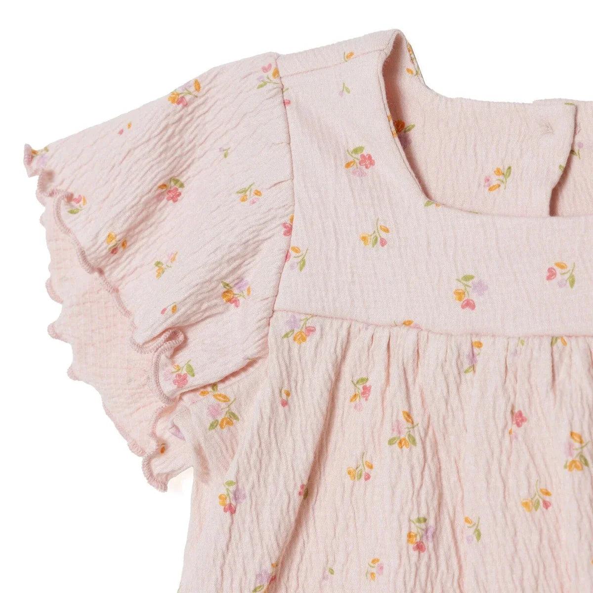 Pink floral baby top close-up, ruffled neckline and flutter sleeves