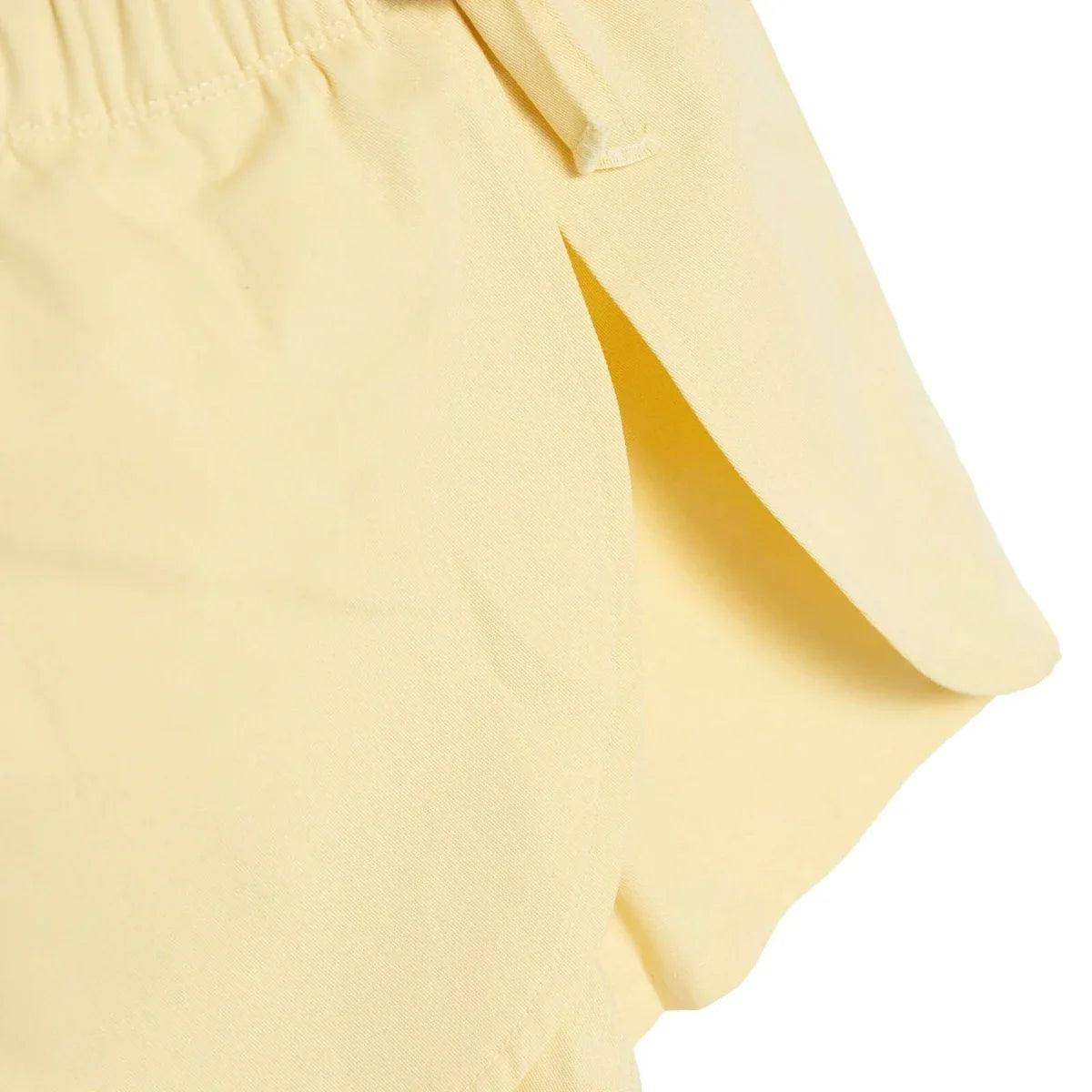 Pale yellow baby shorts with relaxed fit and curved hem