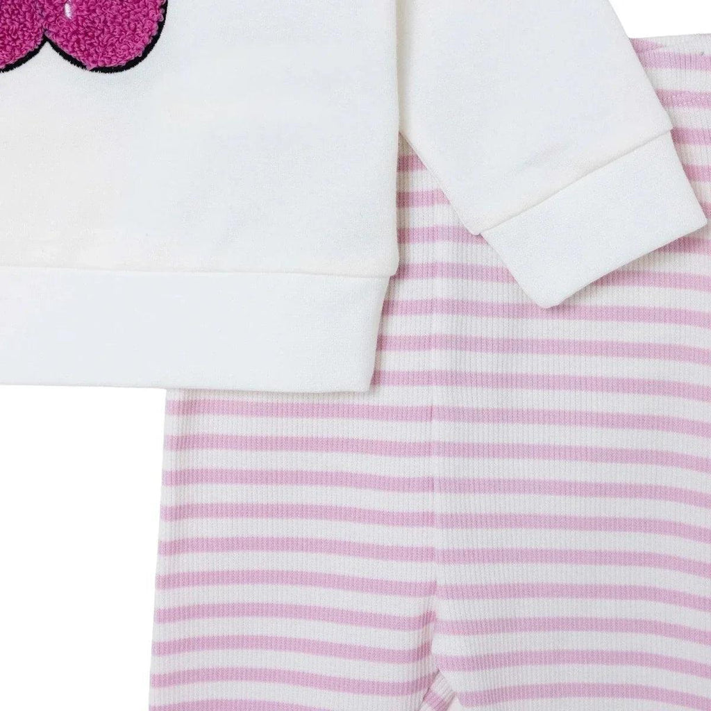 White sweatshirt sleeve with cuff over pink-and-white striped leggings