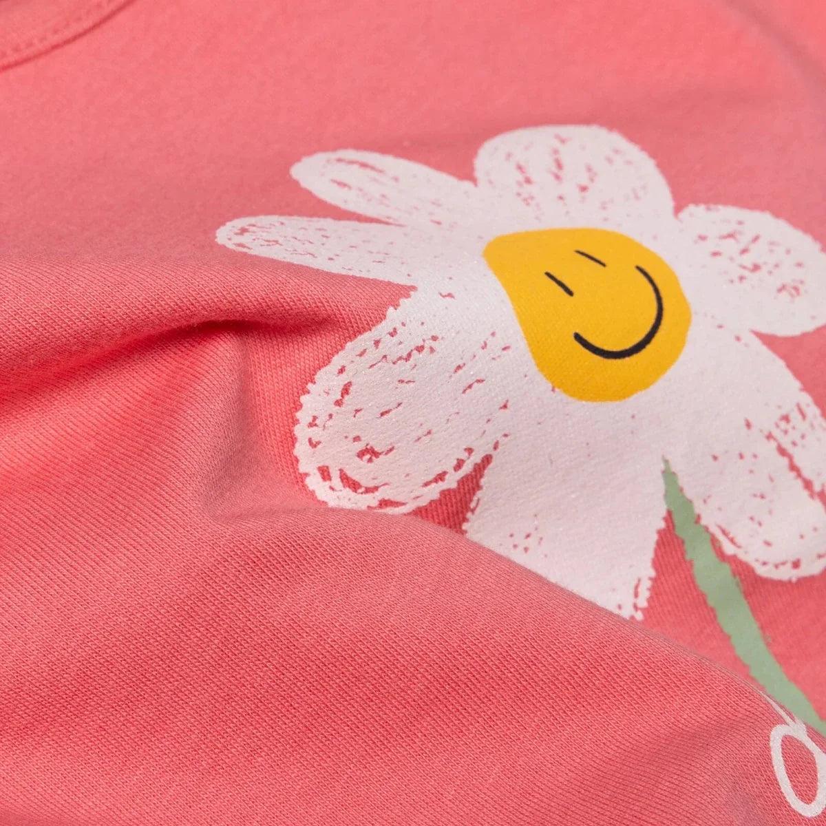 Coral jersey fabric with daisy graphic close-up and yellow smiley center