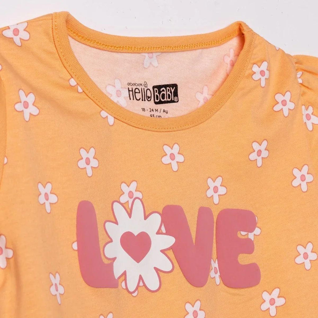 Salmon orange baby jersey T-shirt close-up of LOVE heart graphic and floral print