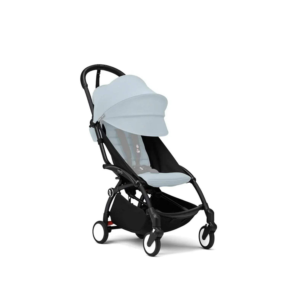 White stroller frame with black canopy and padded seat, front wheel visible