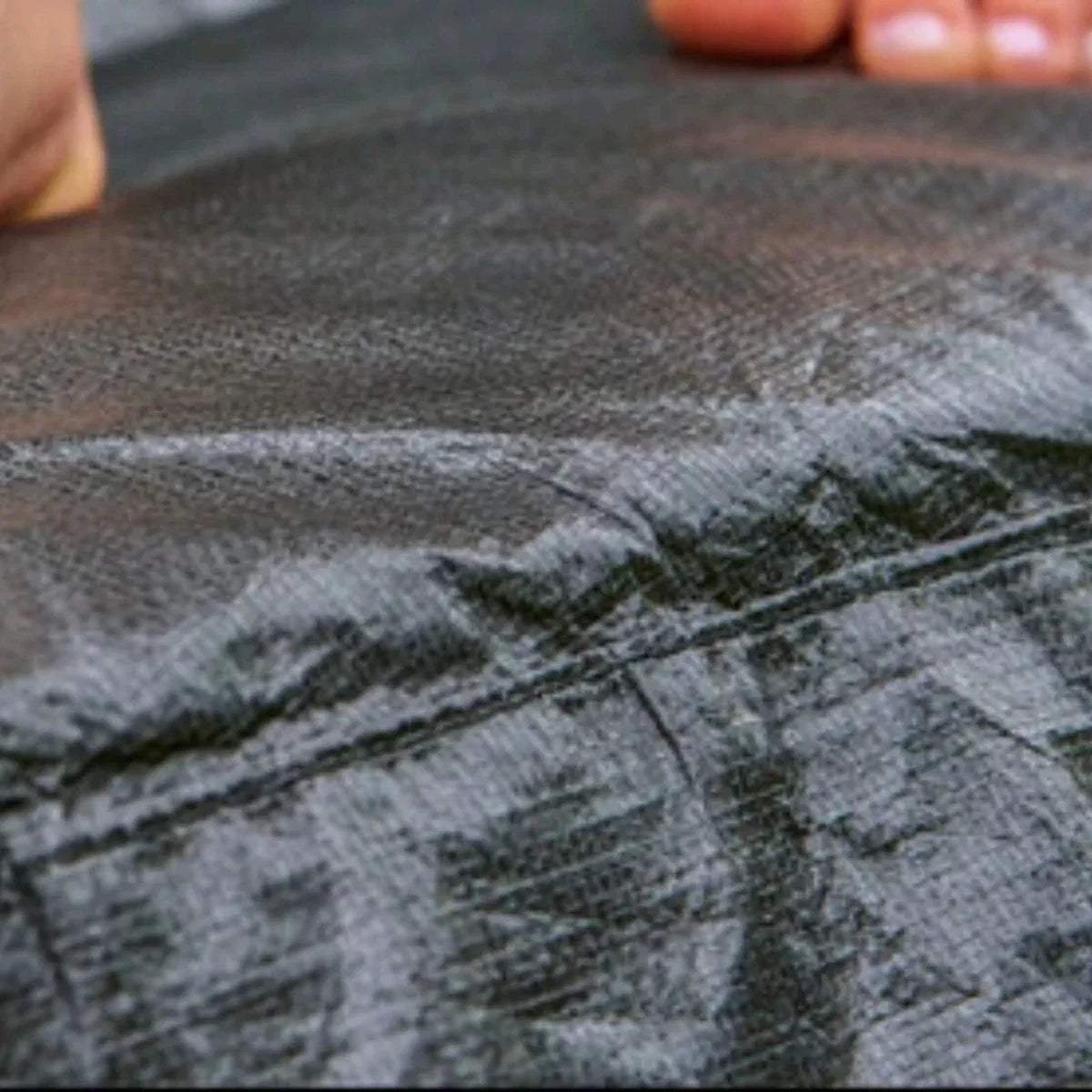 Trampoline jumping mat close-up, dark gray textured fabric surface
