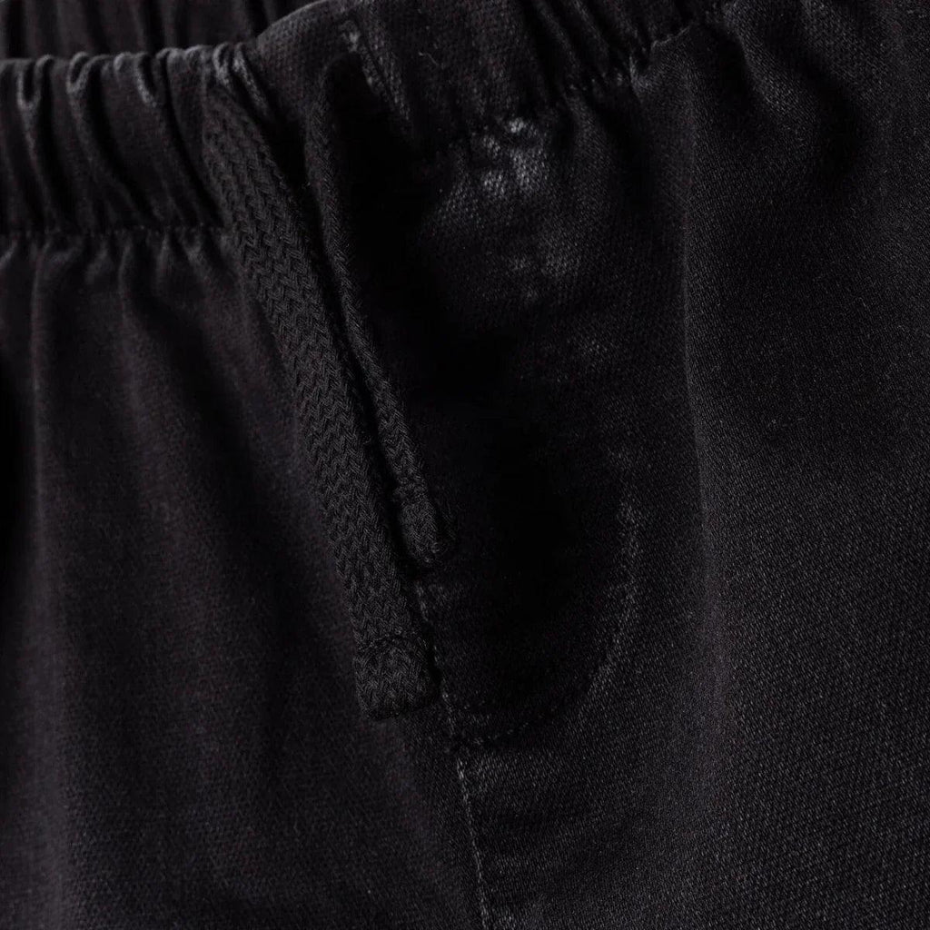 Black denim trousers close-up: inner fly placket and top seam