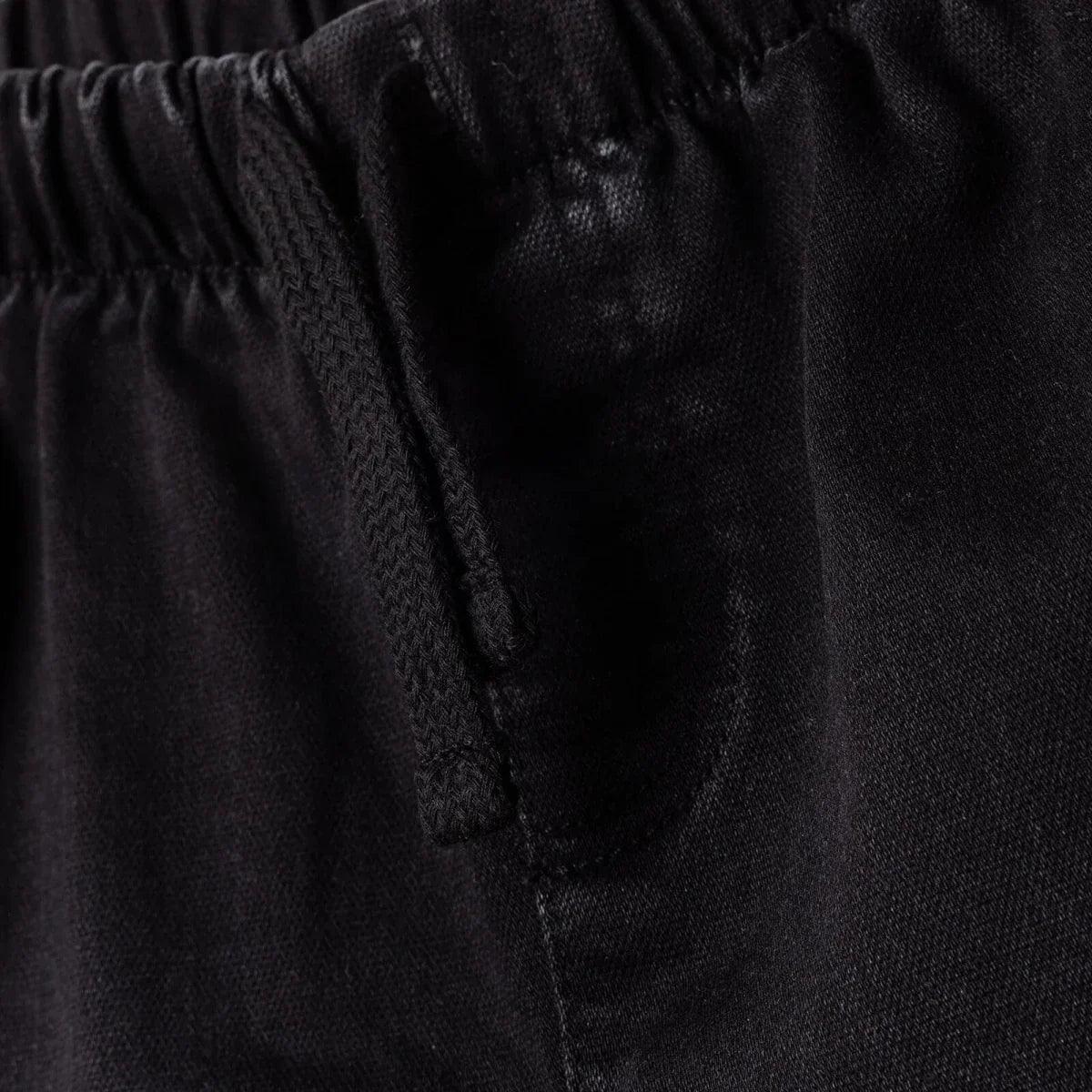 Black denim trousers close-up: inner fly placket and top seam
