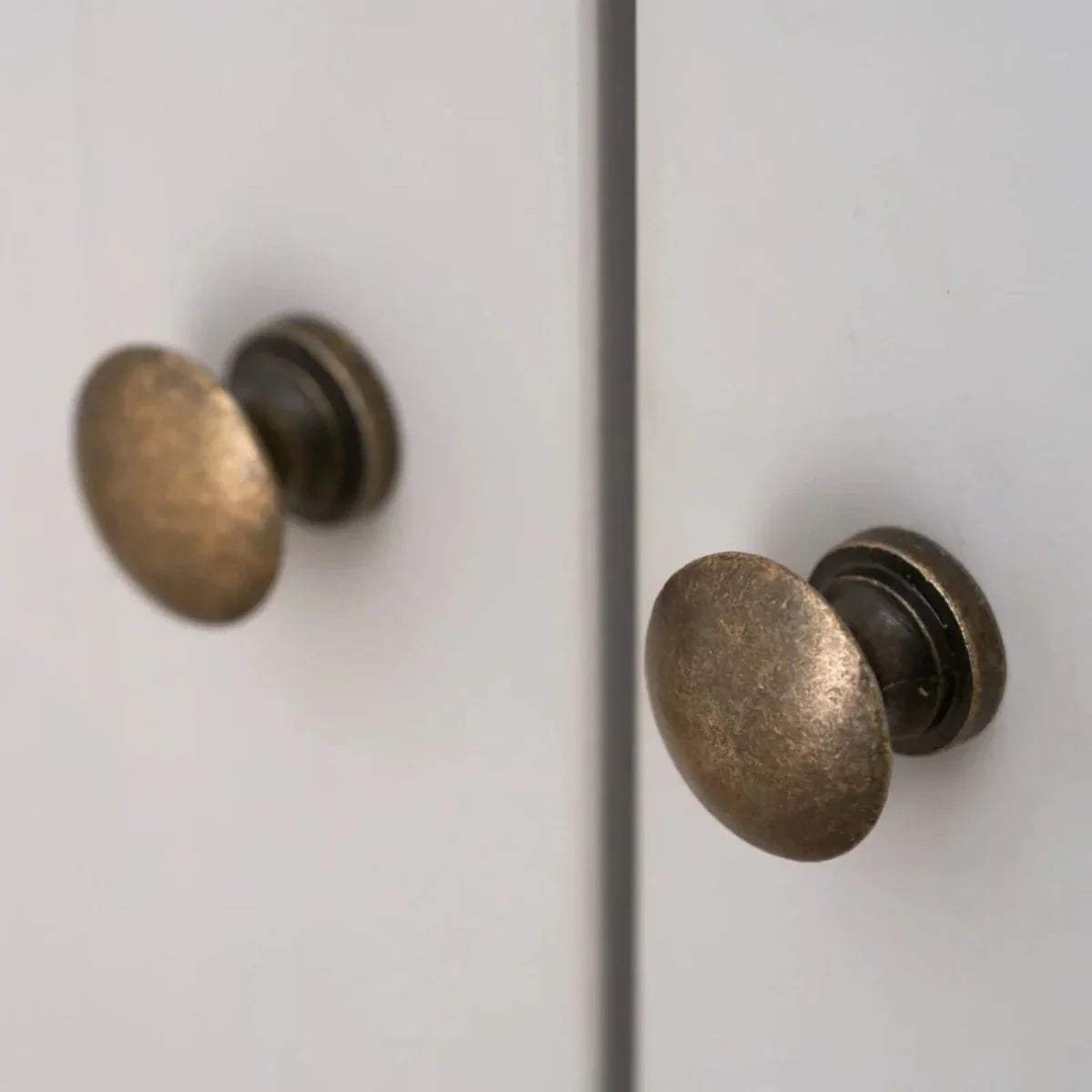 Brass round door knobs on white wardrobe doors