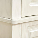White cabinet corner with decorative paneling and black round handle
