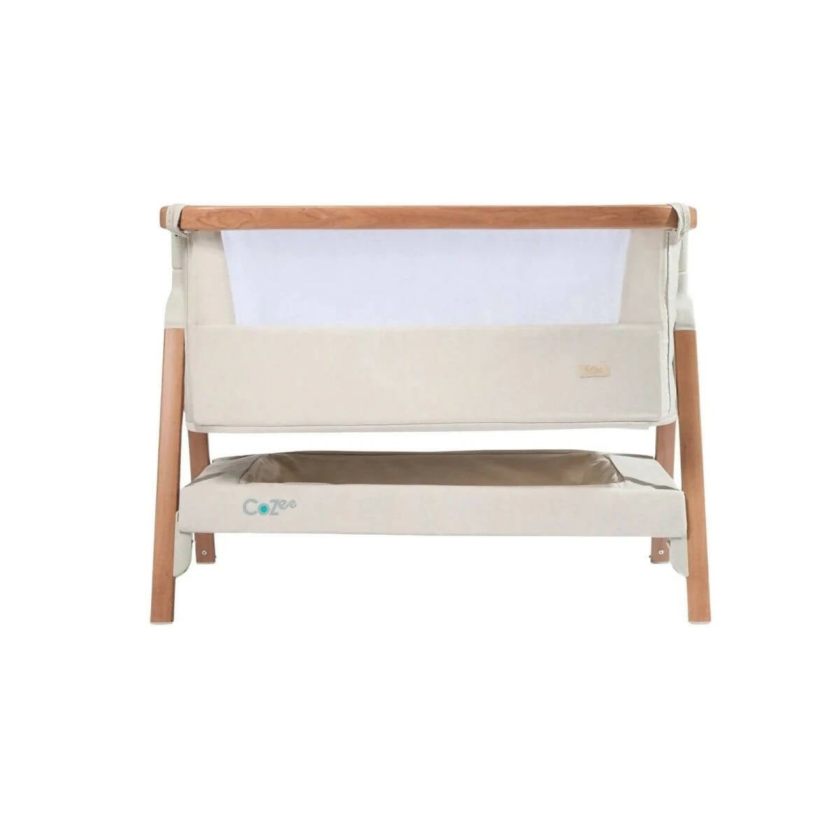Ecru bedside crib with padded front panel and walnut-colored top rail