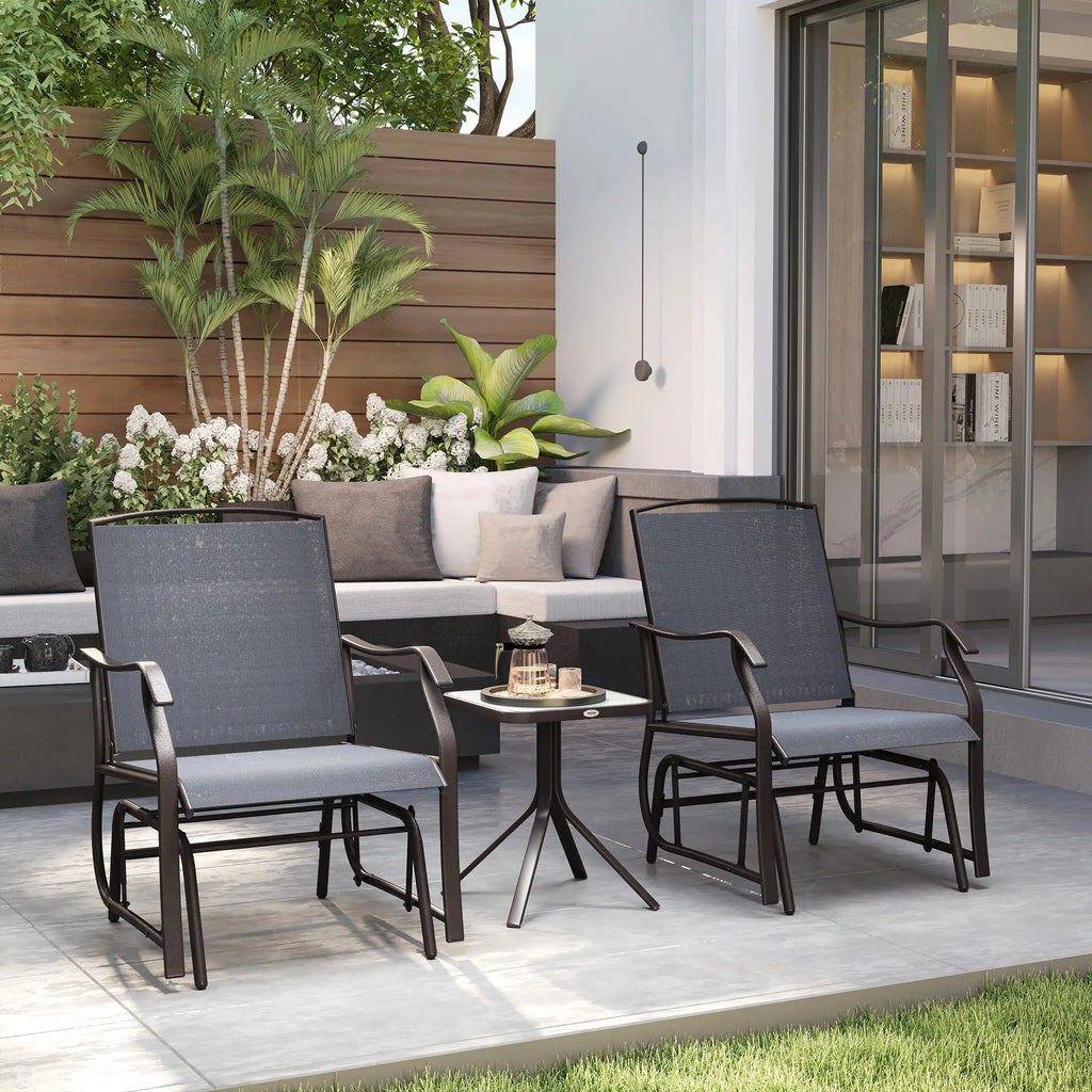 Two grey textilene patio rocking chairs with a small glass-top table between them