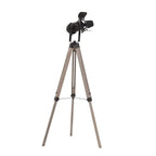 Adjustable tripod floor lamp with black spotlight head and light wood-tone metal legs